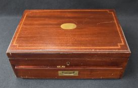 An early to mid 20th century mahogany canteen, having a central brass oval inlay, brass handles