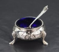 A Victorian silver salt, of circular squat form having a beaded rim, floral decoration to the body