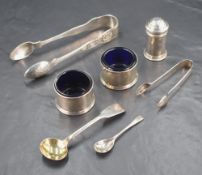A small assortment of silver table accoutrements, comprising two pairs of sugar tongs, one pair