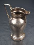 An early George V silver cream jug of baluster form, having geometric banding and angular handle,