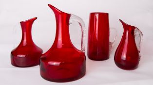 A group of three Whitefriars glass ruby red 'Sparrow Beak' jugs, one large and two smaller, each
