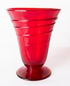 A whitefriars glass footed ribbon trail vase, in ruby red, of flared cylindrical form designed by