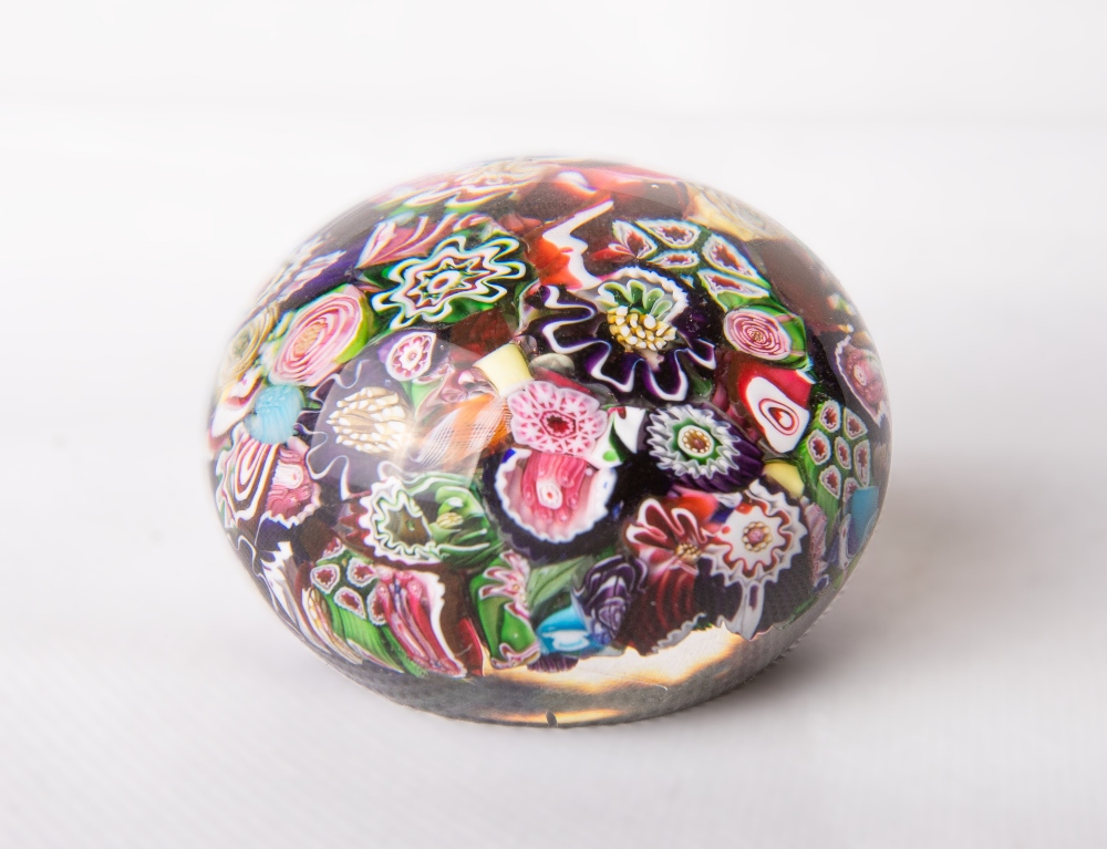 A mid-19th century Clichy scrambled millefiori glass paperweight, of typical domed circular form