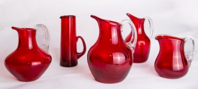 A group of three Whitefriars glass ruby red 'Sparrow Beak' jugs, each a varient to include catalogue