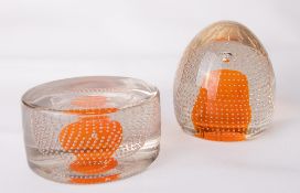 Two Whitefriars glass flint encased bubble over tangerine core paperweights, catalogue numbers