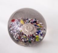 An interesting early 20th century glass military interest paperweight, of typical domed circular