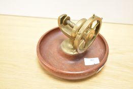 A vintage mid century brass and mahogany 'Ships Wheel' nut cracker with dished circular stand and