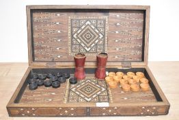A 20th Century Persian backgammon board, the marquetry case with mother of pearl and ebony wood