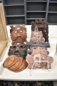 A collection of wooden and terracotta masks, of Eastern and South American origin.