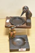 Two circa 1930s wooden ashtrays, both with novelty bird studies to sides, and one with Bakelite