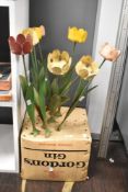 An assorted group of retro metal drinks holders in the form of flowers, each measuring 44cm high