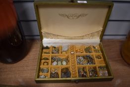 A golden jewellery box with floral decoration, containing a selection of costume jewellery including