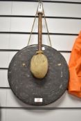 A vintage cast metal gong with large beater.