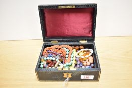 A green lockable jewellery box with key, containing a collection of beaded necklaces including a