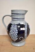 A mid-20th Century West German stoneware wine pitcher, of Westerwald style, decorated in relief with