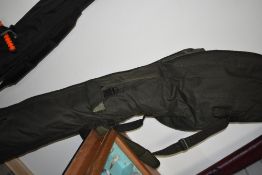 A Large Carp Kinetics rod bag containing two fishing umbrellas rod rests and keep net