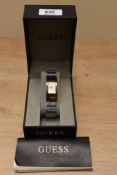 A Guess wristwatch in Guess case, the rectangular champagne dial having no markers within convex