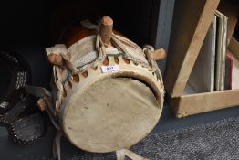 An African animal skin drum, with carved decoration to body.
