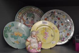A small selection of Oriental style decorative plates and a very cheery Buddha figure.