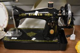 A 1930s/40s hand cranked Singer sewing machine with RAF decals, measuring 50cm long