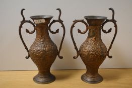 A pair of 19th/20th Century cast metal and twin handled vases, of Eastern design, each measuring
