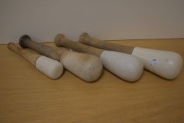 A group of four ceramic tipped wooden pestles, of varying size, each with signs of use, one with