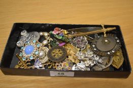 An assortment of costume brooches, comprising large statement brooches, paste set examples, souvenir