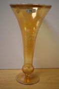 A vintage tinted glass vase of drawn trumpet form with basel knop, wheel engraved with foliate