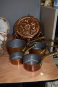 Five copper and brass graduating pans sold alongside decorative mould.