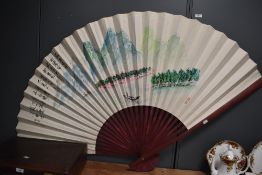 A 20th Century Chinese folding fan, hand decorated with a traditional scene on paper, measuring an