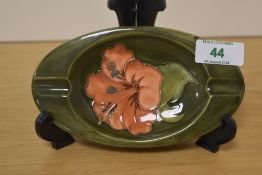 A Moorcroft Pottery Hibiscus pattern oval ashtray, tube lined in the typical manner with central