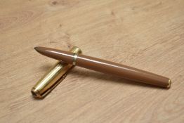 A Parker 51 aerometric fill fountain pen in mustard with a rolled gold cap having twin jewel cap