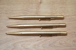 Three Mabie Todd Fyne Poynt propelling pencils in yellow metal having various engine turned designs