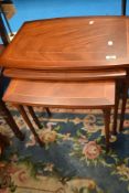 A modern reproduction nest of three yew effect occasional tables