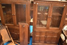 A pair of dark stained Ercol bookcases, having double cupboards under, approx. dimensions W93 D34