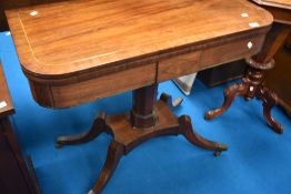 A 19th Century fold over card table on platform base with quatrefoil legs and brass castors,
