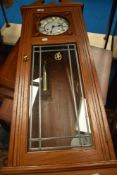 A modern golden oak cased wall clock