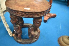 A tribal art style occasional table with figure supports