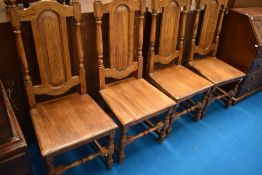 A set of four modern colonial style dining chairs having solid seats and backs