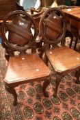 A pair of 19th Century mahogany hall chairs having shield backs and solid seats
