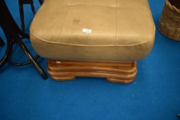 A modern leather footstool/pouffe on wooden frame
