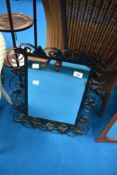 A decorative wall mirror having wrought frame