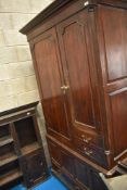 An 18th Century oak linen press having shelved cupboard and open interior over faux kist base,