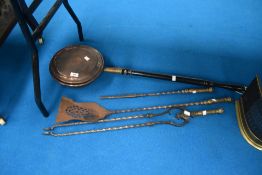 A traditional copper warming pan and selection of fire tools