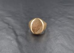 A large 9ct gold signet ring, having an oval panel with engraved line decoration, ring size V, 5.4g