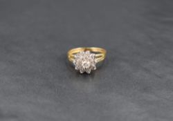 A diamond cluster ring, the central diamond measuring approximately 0.12ct having a step design with