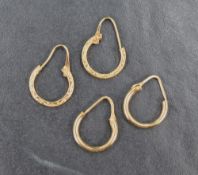 Two pairs of 18ct gold hoop earrings, one pair of rounded plain design, the other having engraved