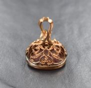 A 9ct gold mounted seal fob, the ornate pierced mount set with a vacant oval carnelian panel, 6.