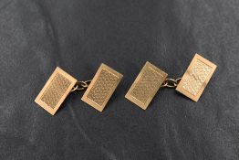 A pair of 9ct gold cufflinks, having rectangular panels with engine turned decoration and chain