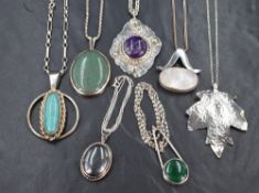 Seven silver and white metal pendants with chains including artisan style, hematite, polished